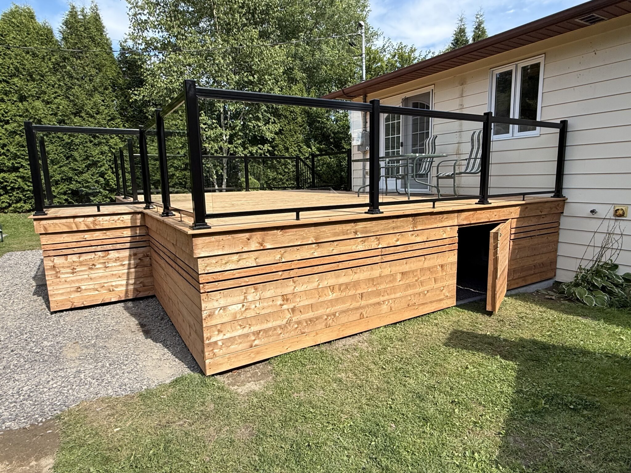 Patio en bois avec garde-corps de verre construit par Rénovation Provost